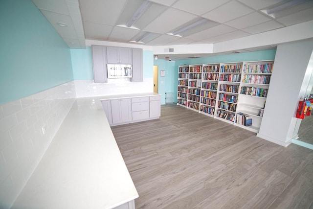 6301 N Sheridan Rd Unit 6D, Chicago, IL 60660 - unfurnished room with visible vents, bookshelves, light wood finished floors, and a paneled ceiling
