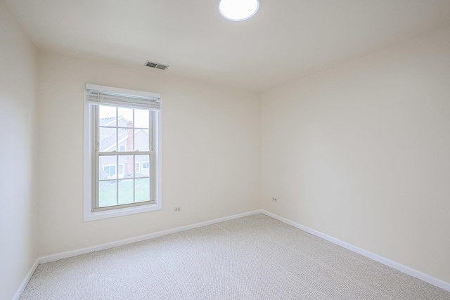 empty room with carpet, visible vents, and baseboards