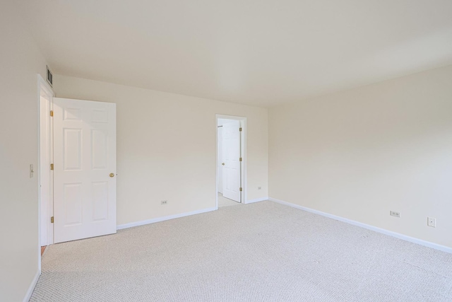 unfurnished room featuring visible vents, baseboards, and light colored carpet
