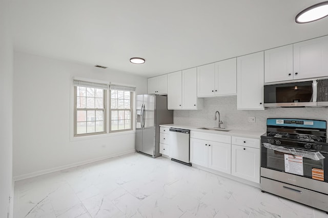 kitchen with visible vents, a sink, light countertops, appliances with stainless steel finishes, and marble finish floor