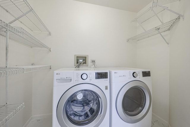 washroom featuring baseboards, marble finish floor, separate washer and dryer, and laundry area