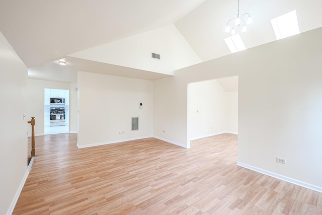 unfurnished room with a chandelier, light wood-type flooring, visible vents, and high vaulted ceiling