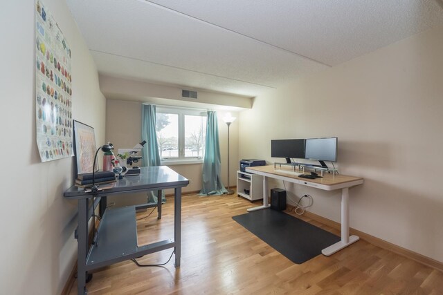 office featuring baseboards, visible vents, and light wood-style flooring