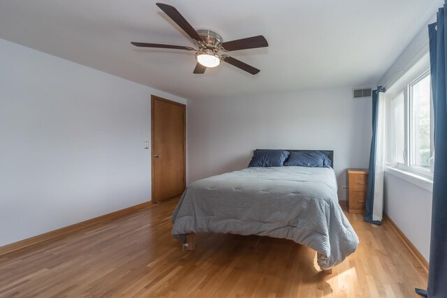 bedroom featuring baseboards, ceiling fan, light wood-type flooring, and visible vents