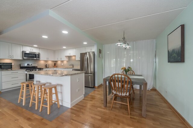 kitchen with recessed lighting, a sink, white cabinets, and stainless steel appliances