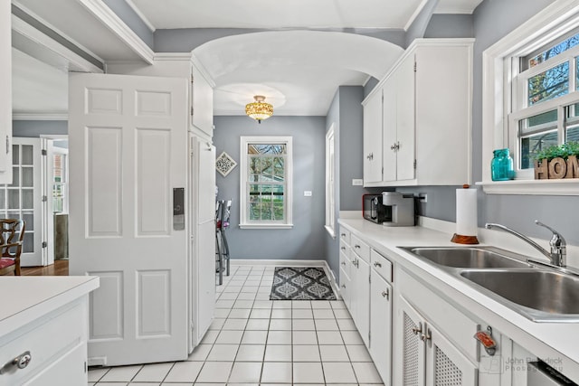 kitchen with light countertops, white cabinets, and a sink