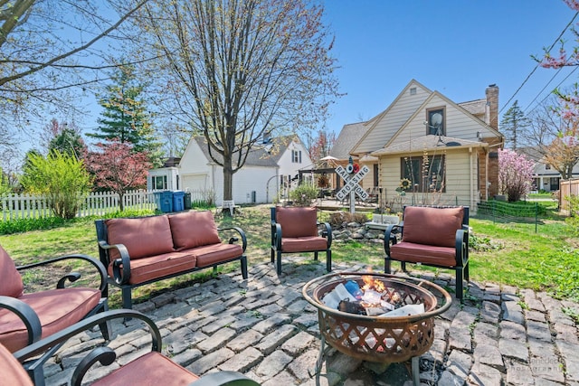 view of patio featuring an outdoor living space with a fire pit, an outbuilding, and fence