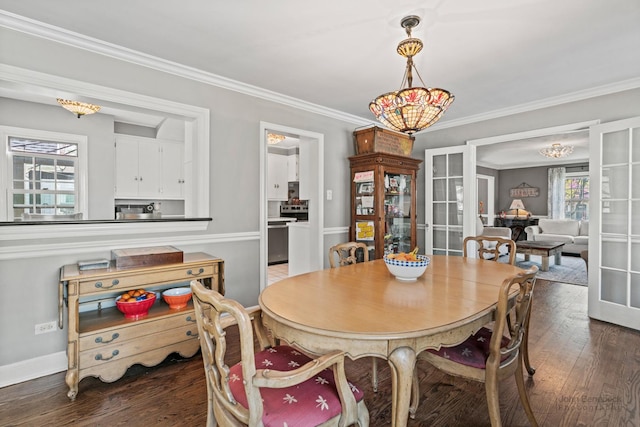 dining space with crown molding, wood finished floors, and baseboards