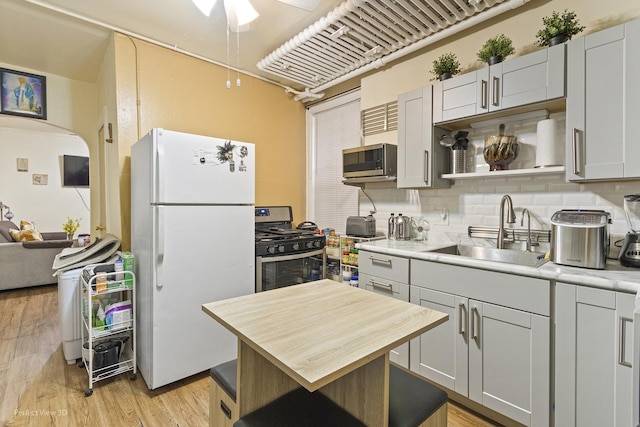 1633 W N Ave, Chicago, IL 60622 - kitchen with ceiling fan, appliances with stainless steel finishes, tasteful backsplash, a sink, and light wood-style flooring