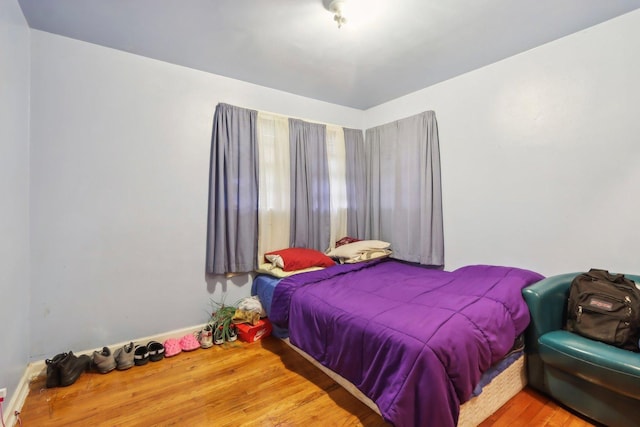 bedroom featuring wood finished floors and baseboards