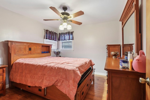 bedroom featuring ceiling fan, baseboards, and dark wood-type flooring