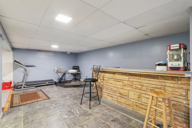 bar featuring a drop ceiling and a bar
