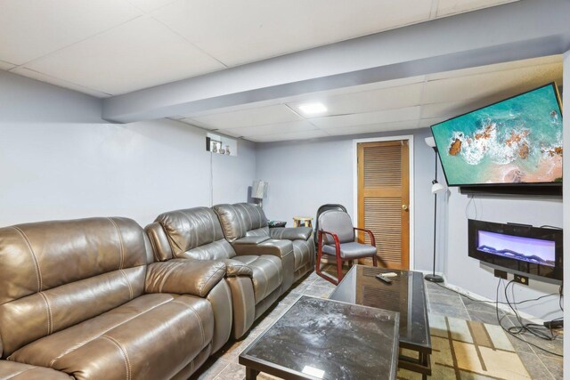 living room with a glass covered fireplace and a drop ceiling