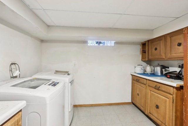 laundry area featuring baseboards, washer and dryer, and cabinet space