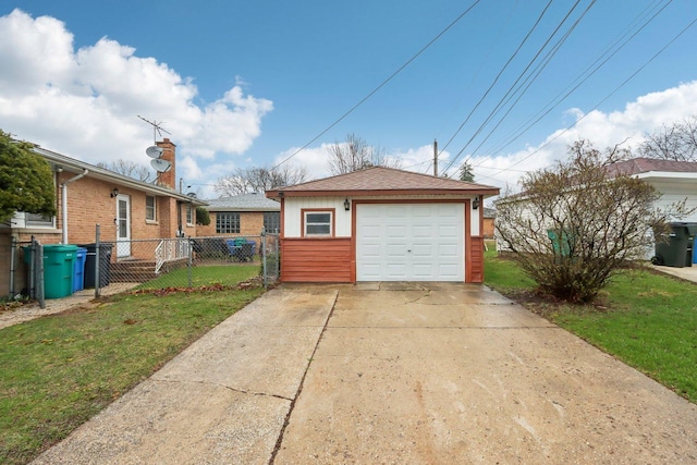 detached garage featuring concrete driveway and fence