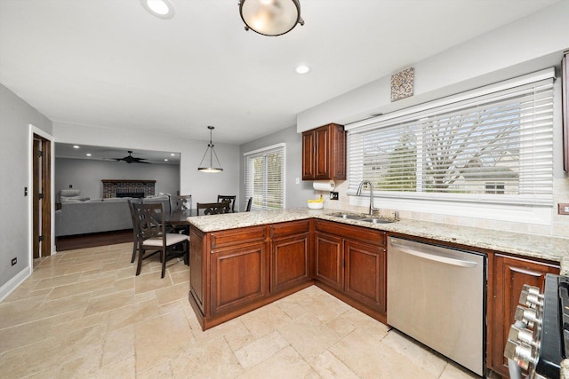 kitchen featuring recessed lighting, a sink, stone tile flooring, a fireplace, and dishwasher