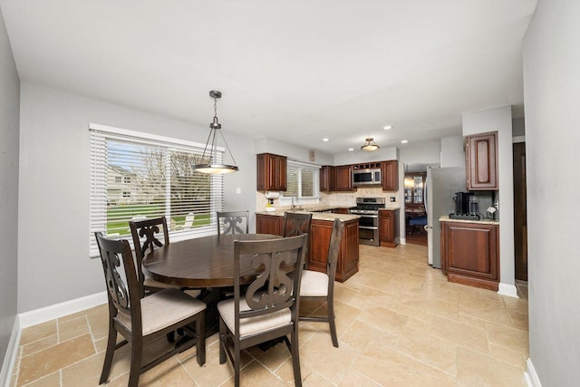 dining room with recessed lighting, stone tile flooring, and baseboards