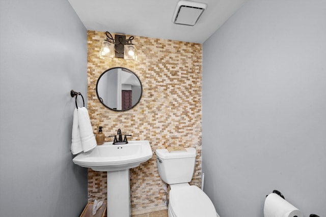 half bath with visible vents and toilet