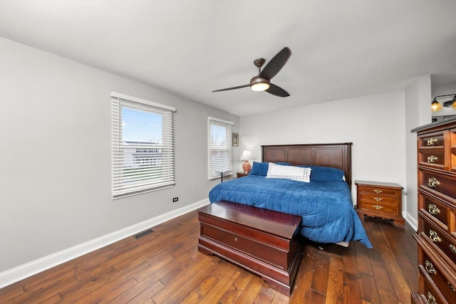 bedroom featuring baseboards, visible vents, a ceiling fan, and dark wood-type flooring