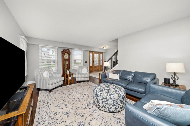 living area with baseboards, wood finished floors, and stairs
