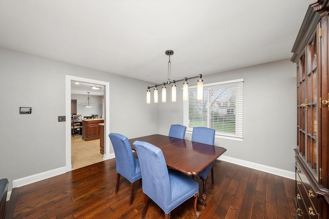 dining space featuring dark wood finished floors and baseboards