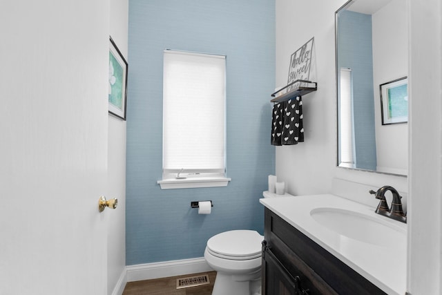 bathroom with baseboards, visible vents, toilet, and vanity