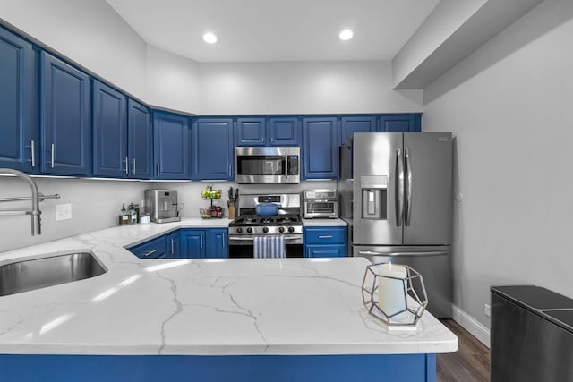 kitchen featuring stainless steel appliances, dark wood-style floors, a sink, recessed lighting, and light stone counters