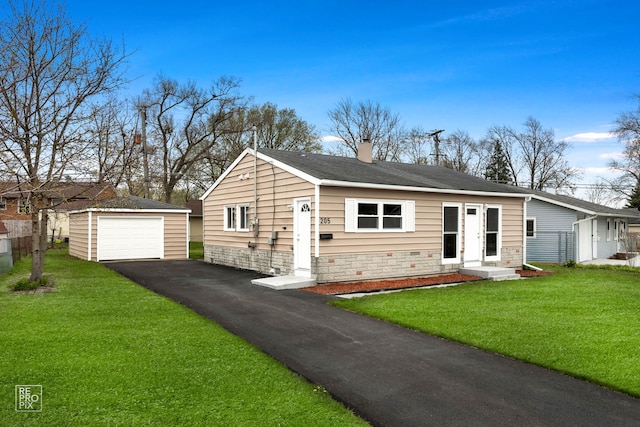 view of front of house with a front lawn, an outbuilding, a chimney, a detached garage, and aphalt driveway