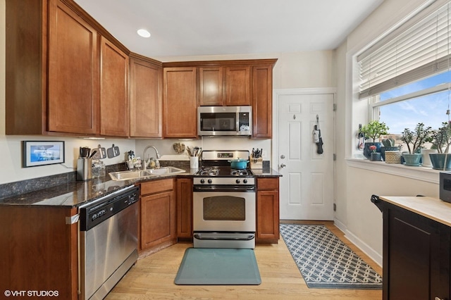 536.5 W Belmont Ave Unit 3N, Chicago, IL 60657 - kitchen with appliances with stainless steel finishes, dark stone countertops, a sink, and light wood-type flooring