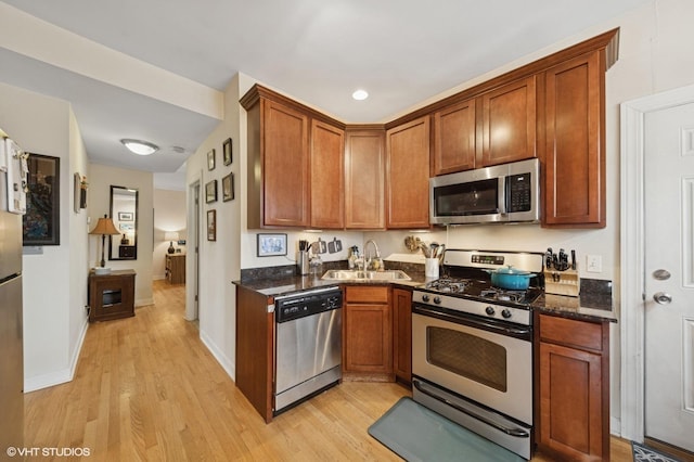 536.5 W Belmont Ave Unit 3N, Chicago, IL 60657 - kitchen with light wood-style floors, dark stone countertops, appliances with stainless steel finishes, and a sink