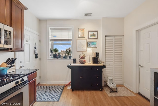 536.5 W Belmont Ave Unit 3N, Chicago, IL 60657 - kitchen featuring baseboards, appliances with stainless steel finishes, light wood-style floors, and visible vents