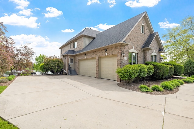 view of property exterior with brick siding, an attached garage, roof with shingles, and concrete driveway
