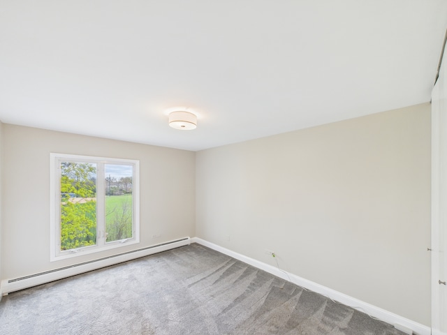 empty room featuring carpet, baseboard heating, and baseboards