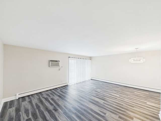 empty room featuring baseboard heating, baseboards, wood finished floors, and a wall mounted air conditioner
