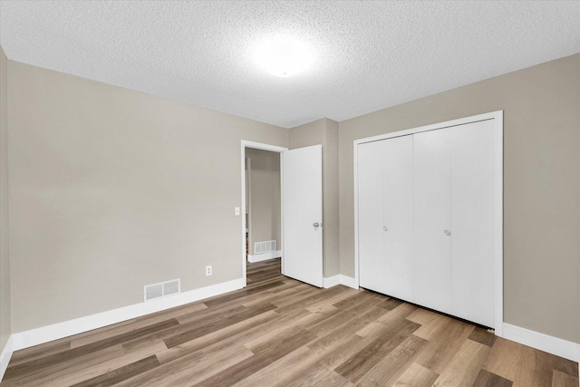 2567 Clayton Blvd Unit 2567, Champaign, IL 61822 - unfurnished bedroom with wood finished floors, baseboards, a closet, and a textured ceiling