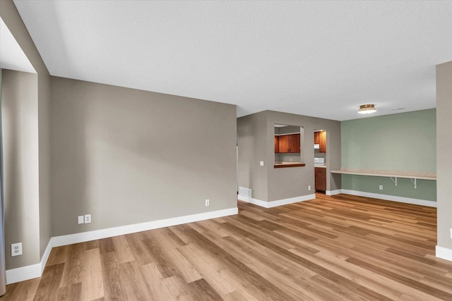 2567 Clayton Blvd Unit 2567, Champaign, IL 61822 - unfurnished living room featuring light wood-style floors, baseboards, and a textured ceiling