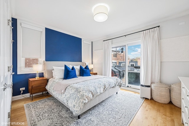 bedroom featuring access to exterior, light wood-style flooring, ornamental molding, and baseboards