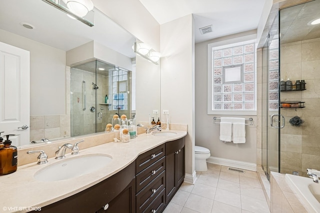 bathroom featuring a shower stall, double vanity, tile patterned floors, toilet, and baseboards