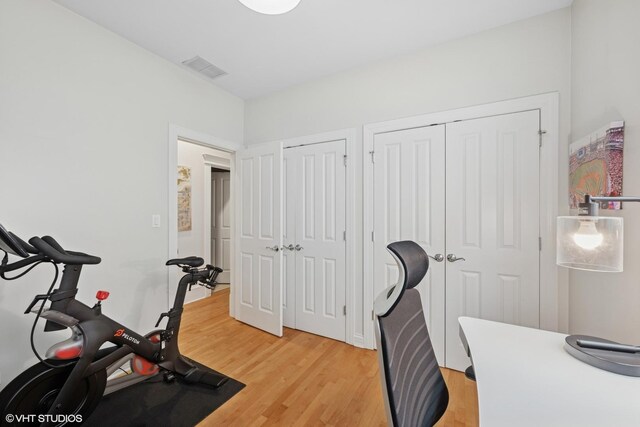 exercise room with light wood finished floors