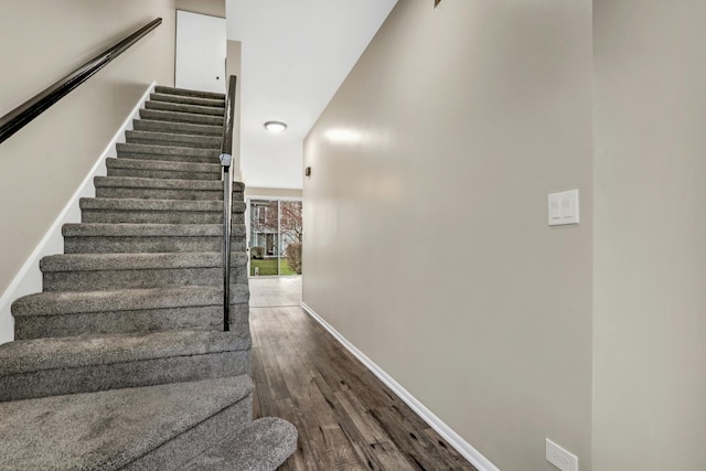 stairway featuring baseboards and wood finished floors