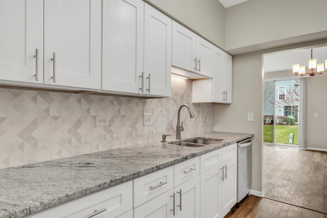 kitchen with a notable chandelier, stainless steel dishwasher, white cabinetry, and a sink