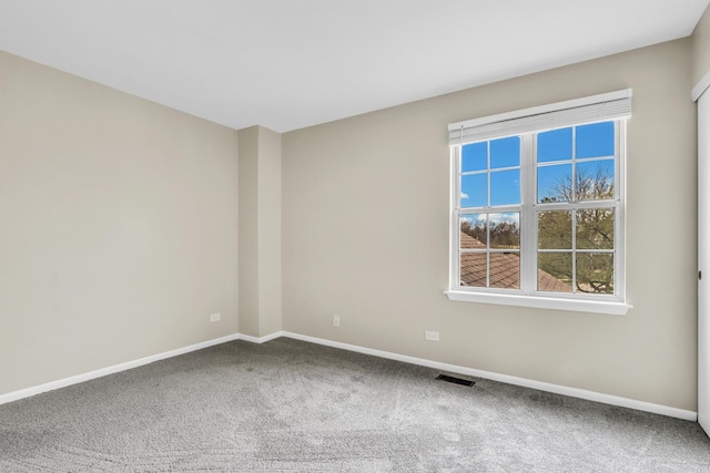 spare room featuring baseboards, carpet flooring, and visible vents