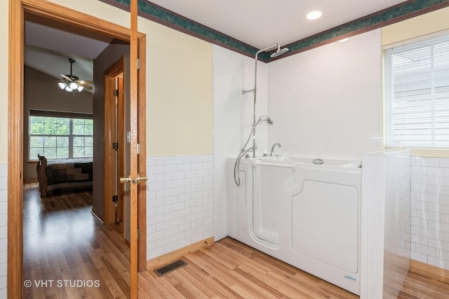 1754 Landreth Ct, Aurora, IL 60504 - full bathroom featuring washer / clothes dryer, tile walls, wood finished floors, visible vents, and a bath