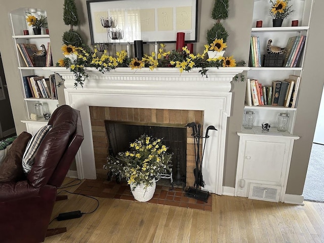 sitting room featuring hardwood / wood-style flooring and a brick fireplace