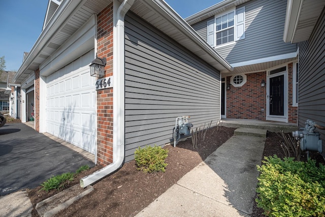 5464 Mayflower Jct, Rolling Meadows, IL 60008 - doorway to property with driveway, an attached garage, and brick siding