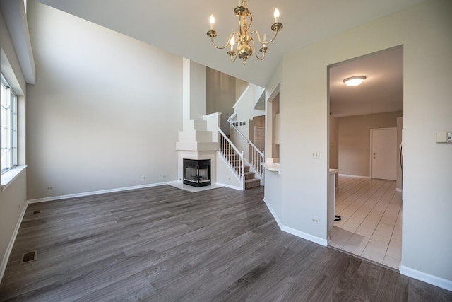 5464 Mayflower Jct, Rolling Meadows, IL 60008 - unfurnished living room with visible vents, baseboards, a fireplace, wood finished floors, and a notable chandelier