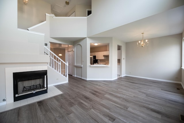 5464 Mayflower Jct, Rolling Meadows, IL 60008 - unfurnished living room featuring a sink, baseboards, a tile fireplace, wood finished floors, and stairs