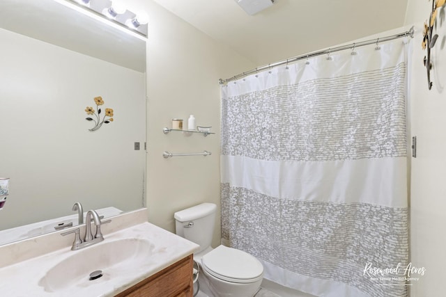 bathroom featuring vanity, curtained shower, and toilet