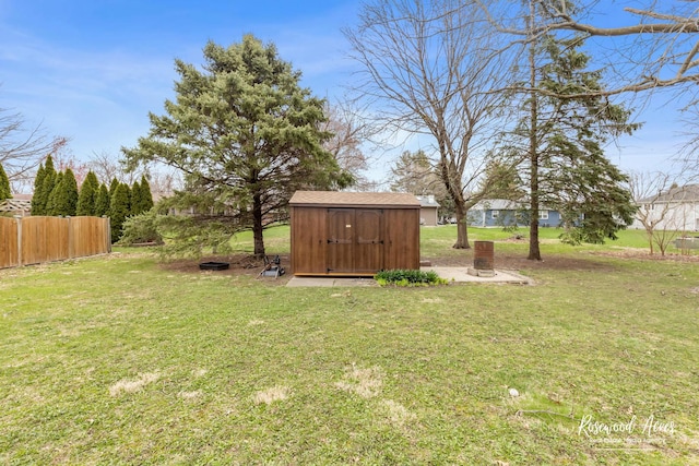 view of yard with fence, an outbuilding, and a storage unit