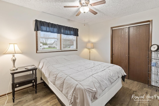 bedroom with a textured ceiling, wood finished floors, a closet, and ceiling fan